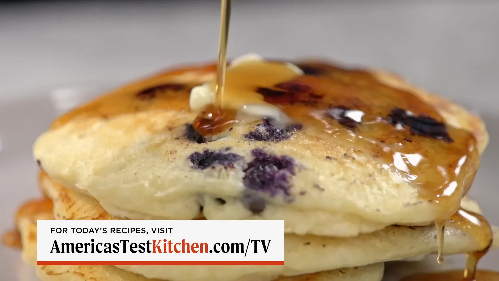 Stack of deluxe blueberry pancakes with butter and maple syrup