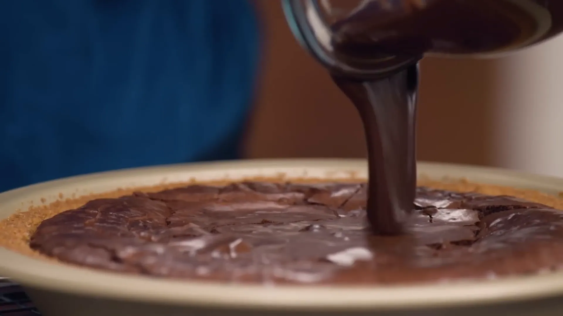 Pouring milk chocolate ganache over brownie layer