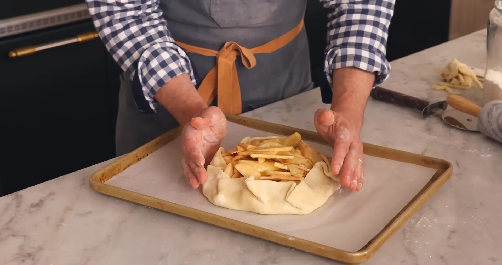 Folding the edges of the galette dough over the apple filling