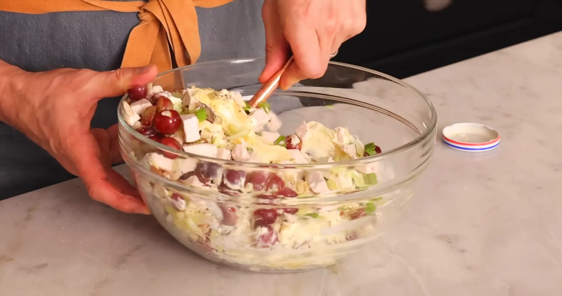 Gently mixing the chicken salad with mayonnaise and mustard dressing