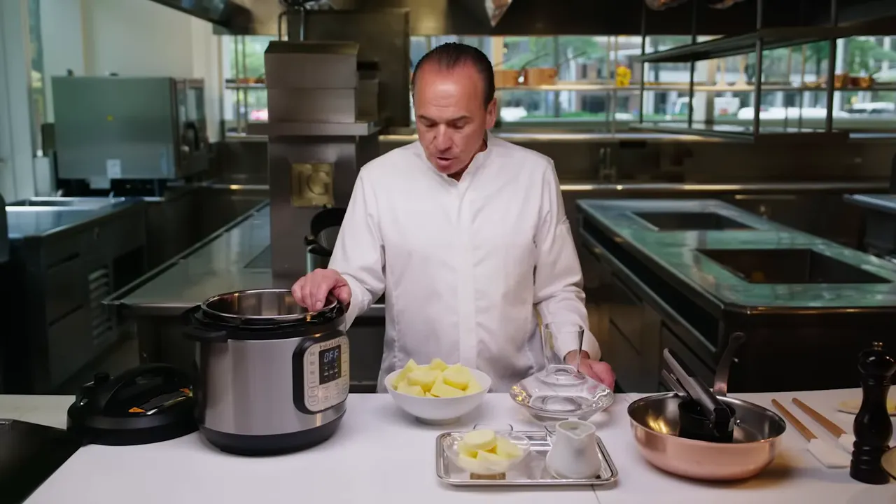 Instant Pot on a countertop with a bowl of peeled Yukon Gold potatoes, a tray of butter and a cream decanter in a professional kitchen.