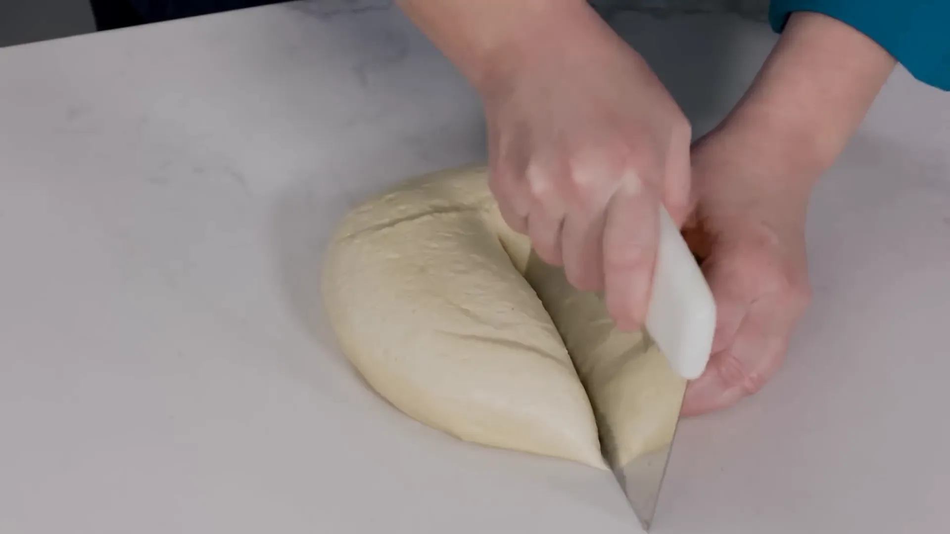 Hands shaping a pretzel rope on the countertop