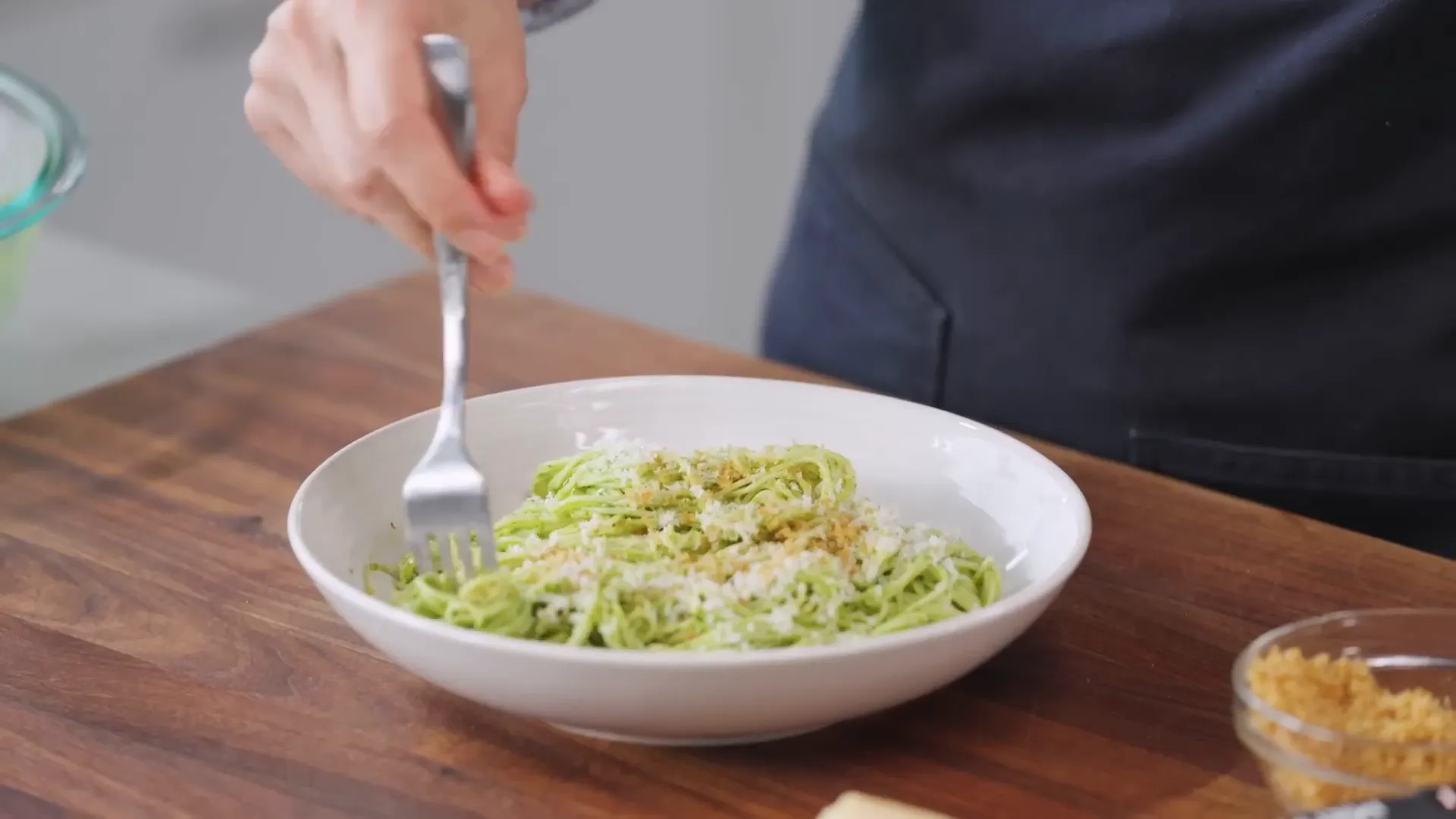 Angel hair pasta tossed with anchovy basil sauce, ready to serve