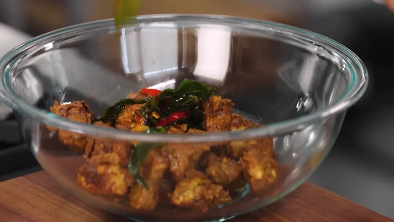 Bowl of glazed Chicken 65 with crispy curry leaves and chilies