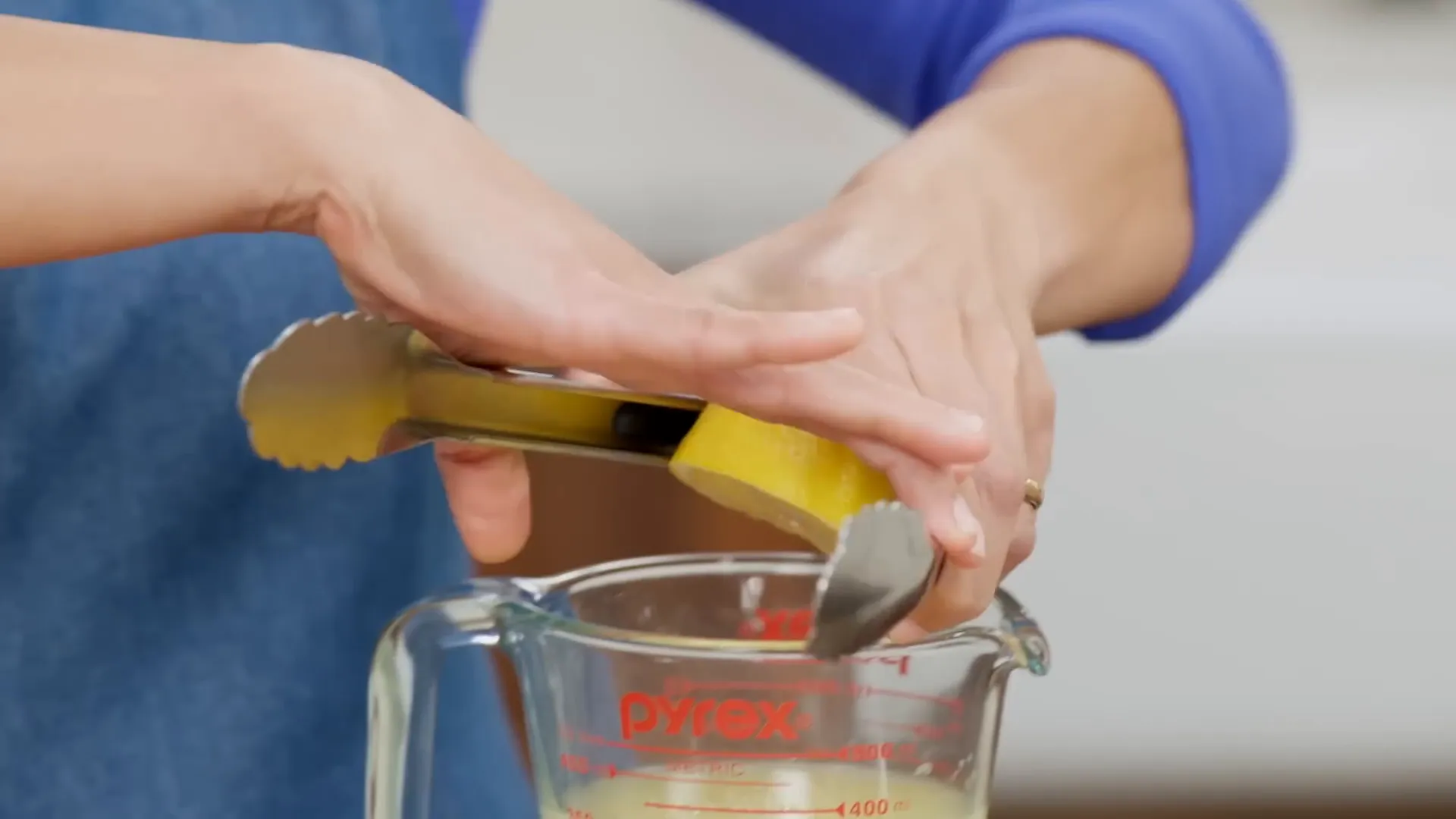 Using tongs to juice lemons