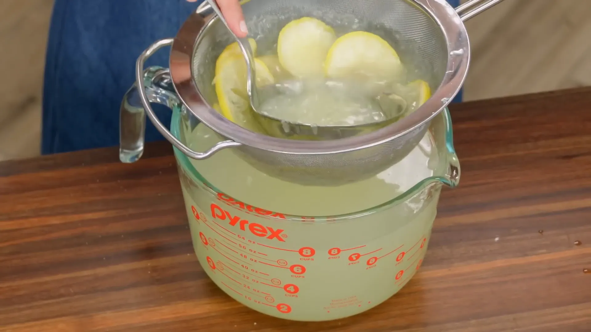 Straining lemonade to remove pulp and seeds