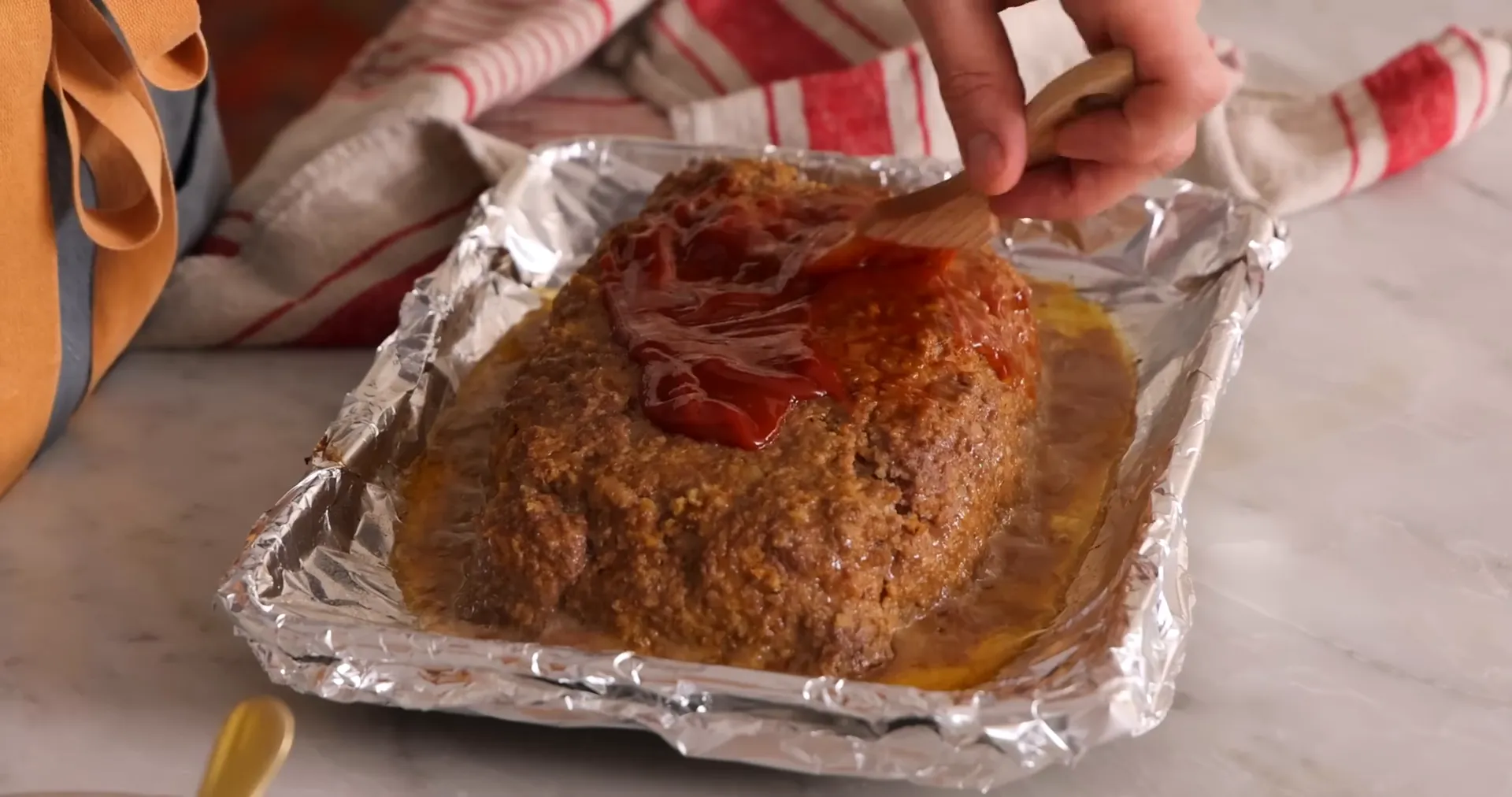 Brushing sauce on meatloaf before final bake