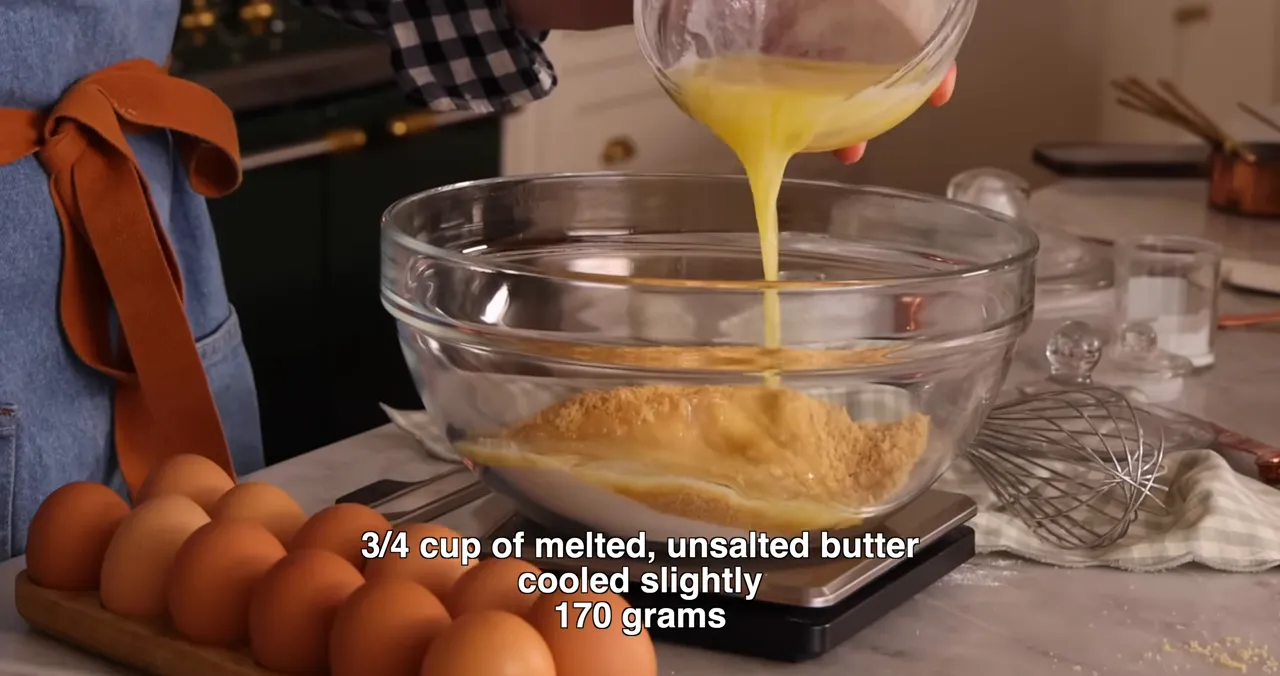 Whisking melted butter with sugars in a bowl