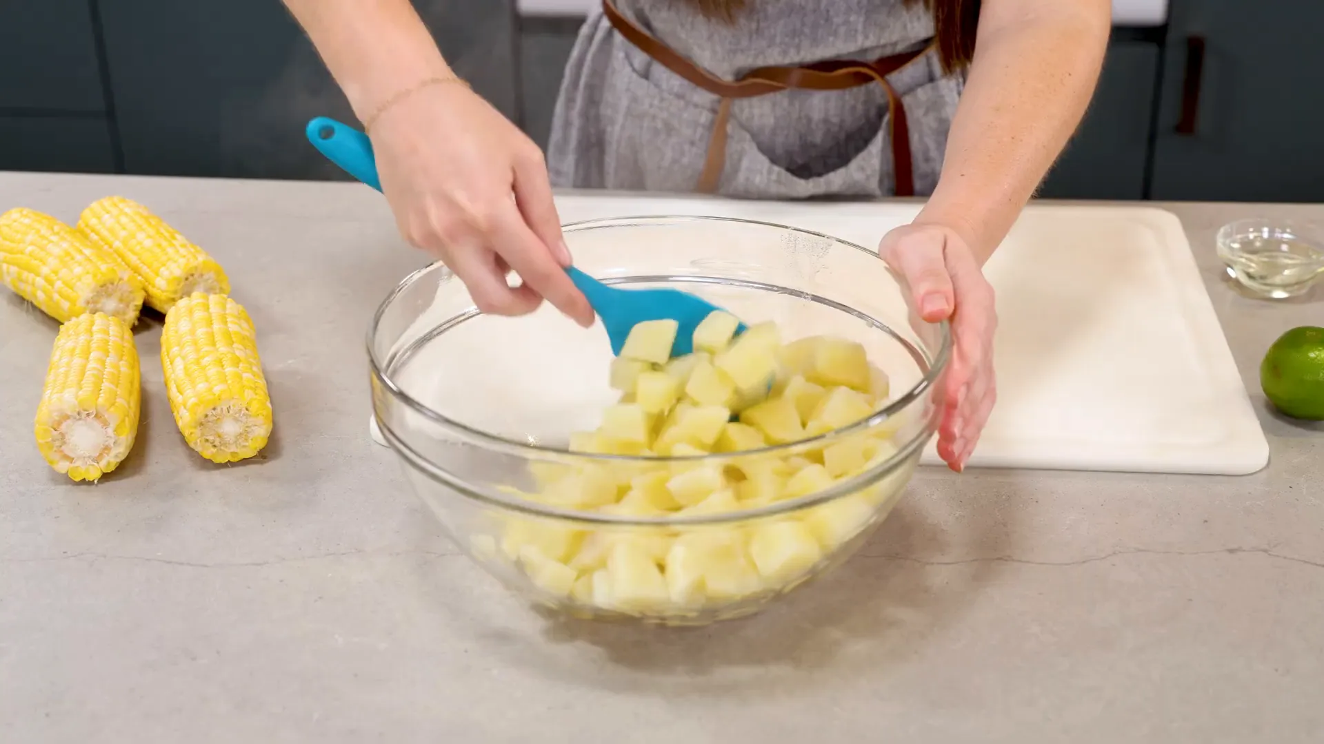 Cooked potatoes in mixing bowl with vinegar drizzled