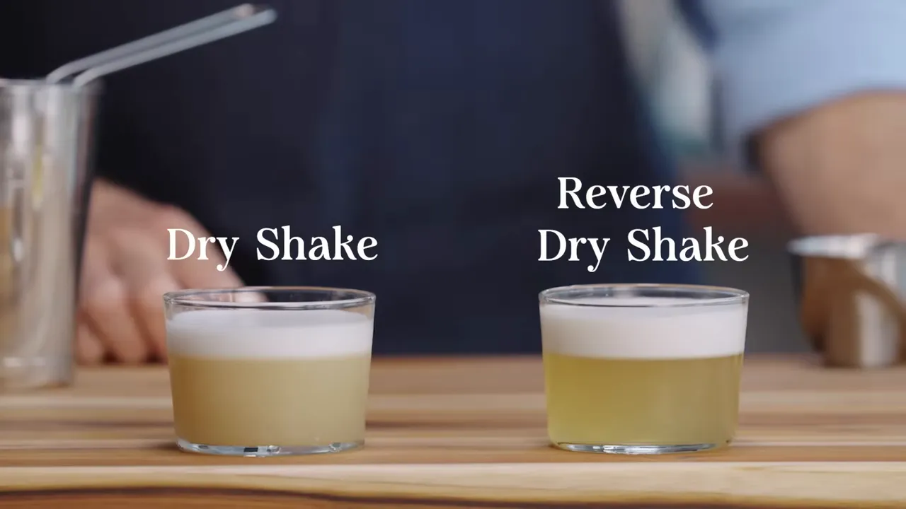 Two short glasses labeled 'Dry Shake' and 'Reverse Dry Shake' showing different foam heights and texture for comparison.
