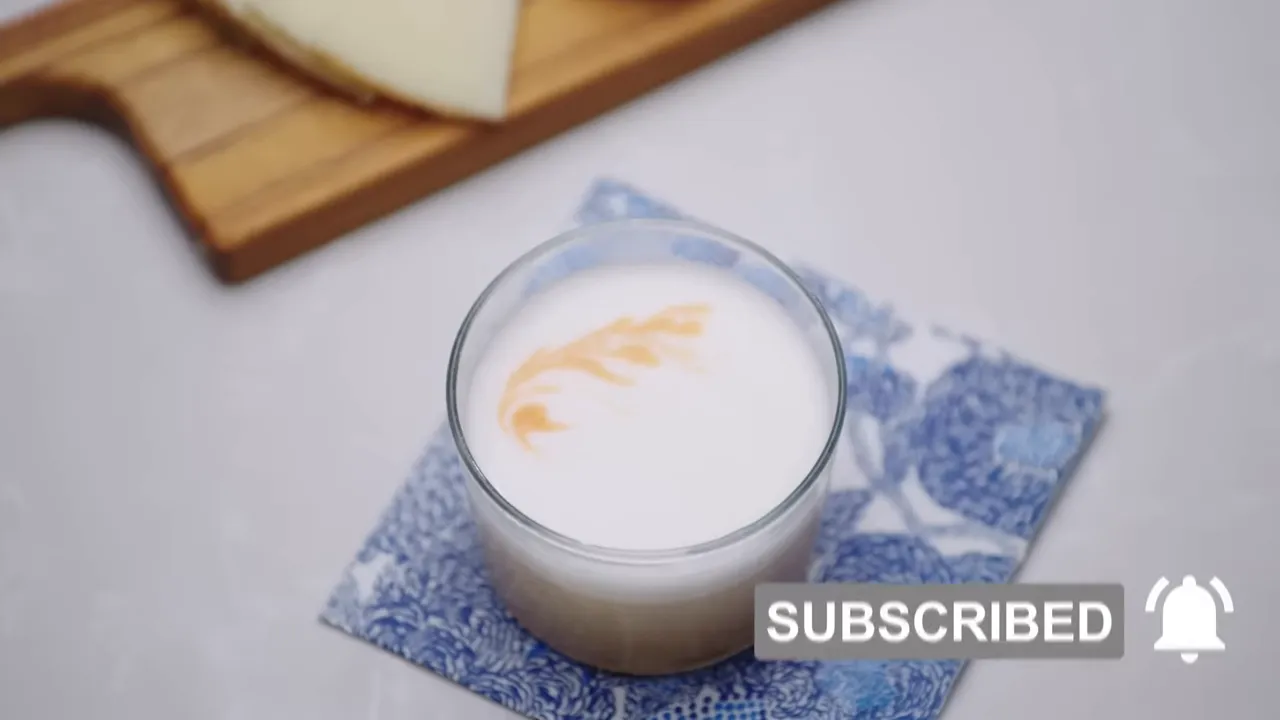 Top-down view of a lowball glass showing thick white egg-white foam with a decorative bitters swirl on top.