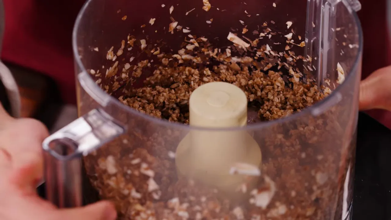 top view of finely pulsed mushrooms inside a food processor