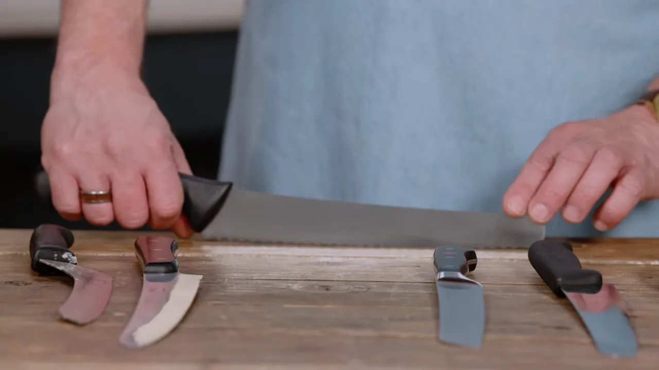 Hands holding a long bread knife showing blade height and heel clearance above work surface