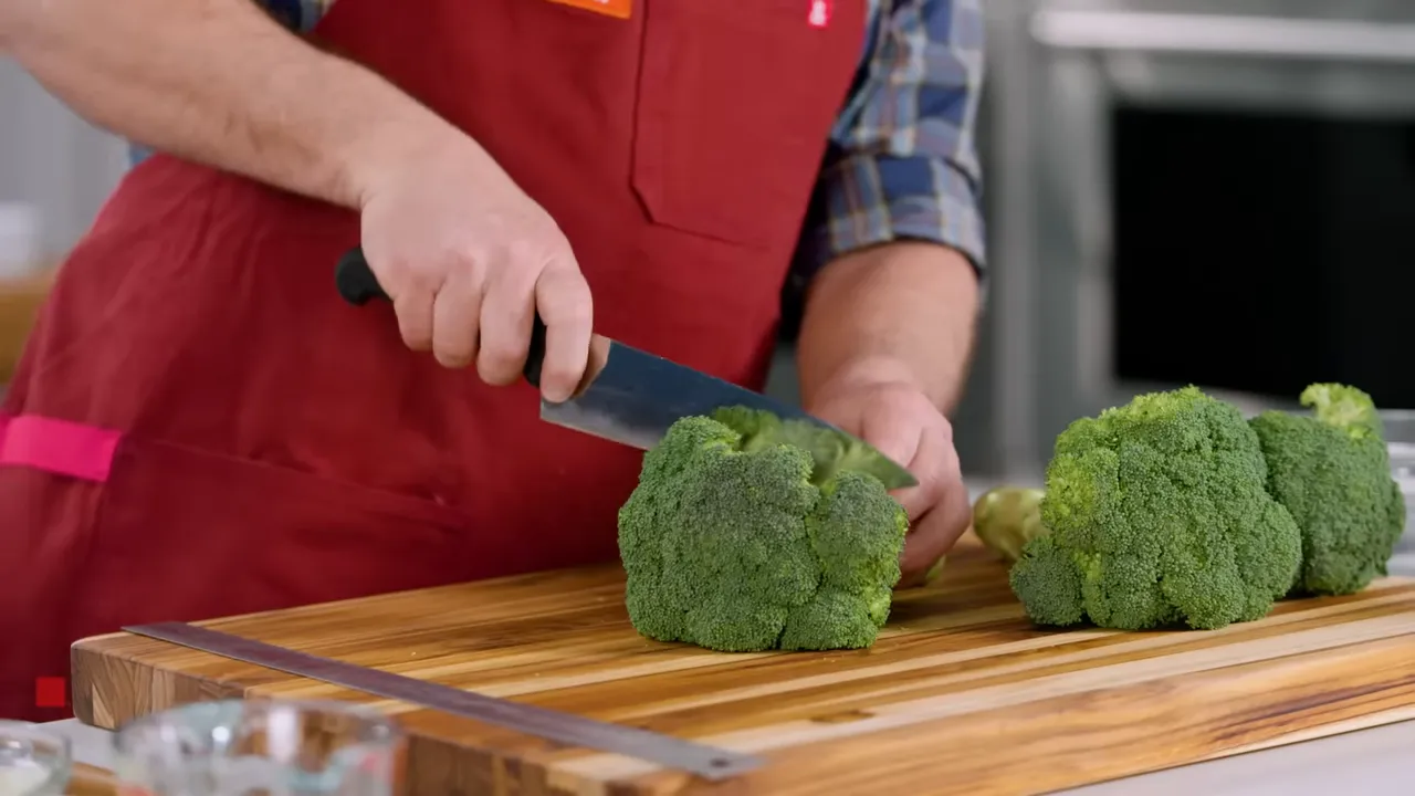 Whole broccoli showing stem and florets on cutting board