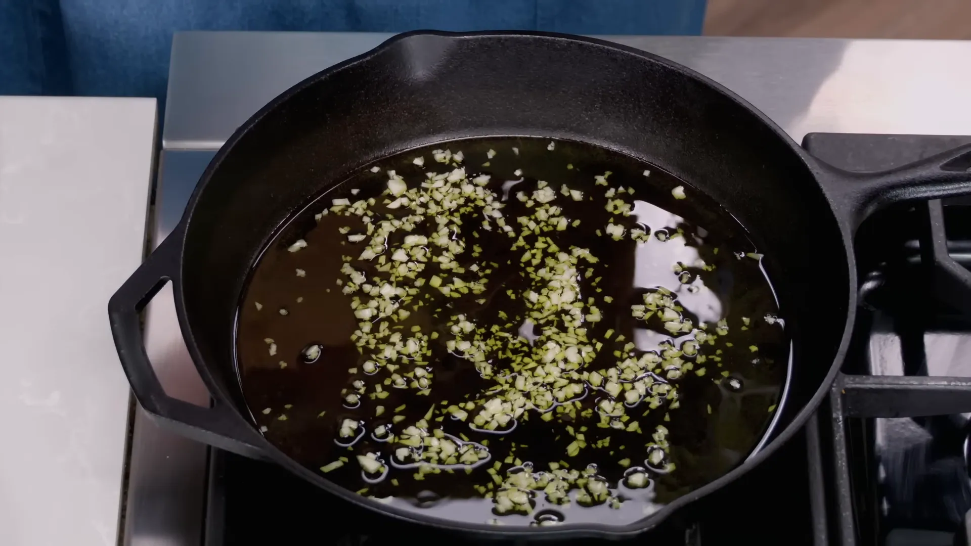 Garlic turning light golden in olive oil in a cast-iron pan
