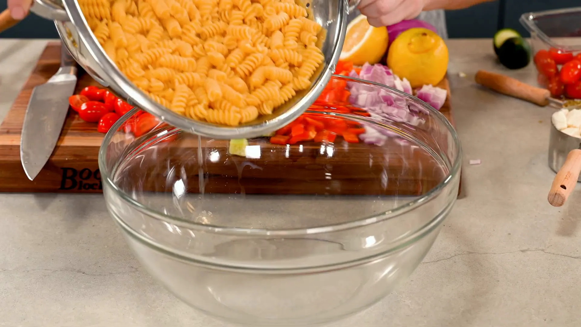 Draining rotini pasta and transferring to a large bowl
