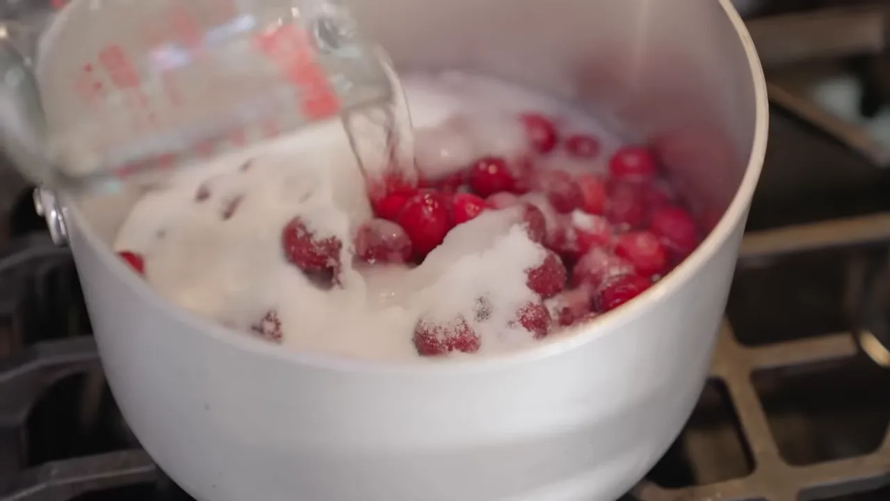 Cranberries cooking in a pot to make cranberry-Aperol base