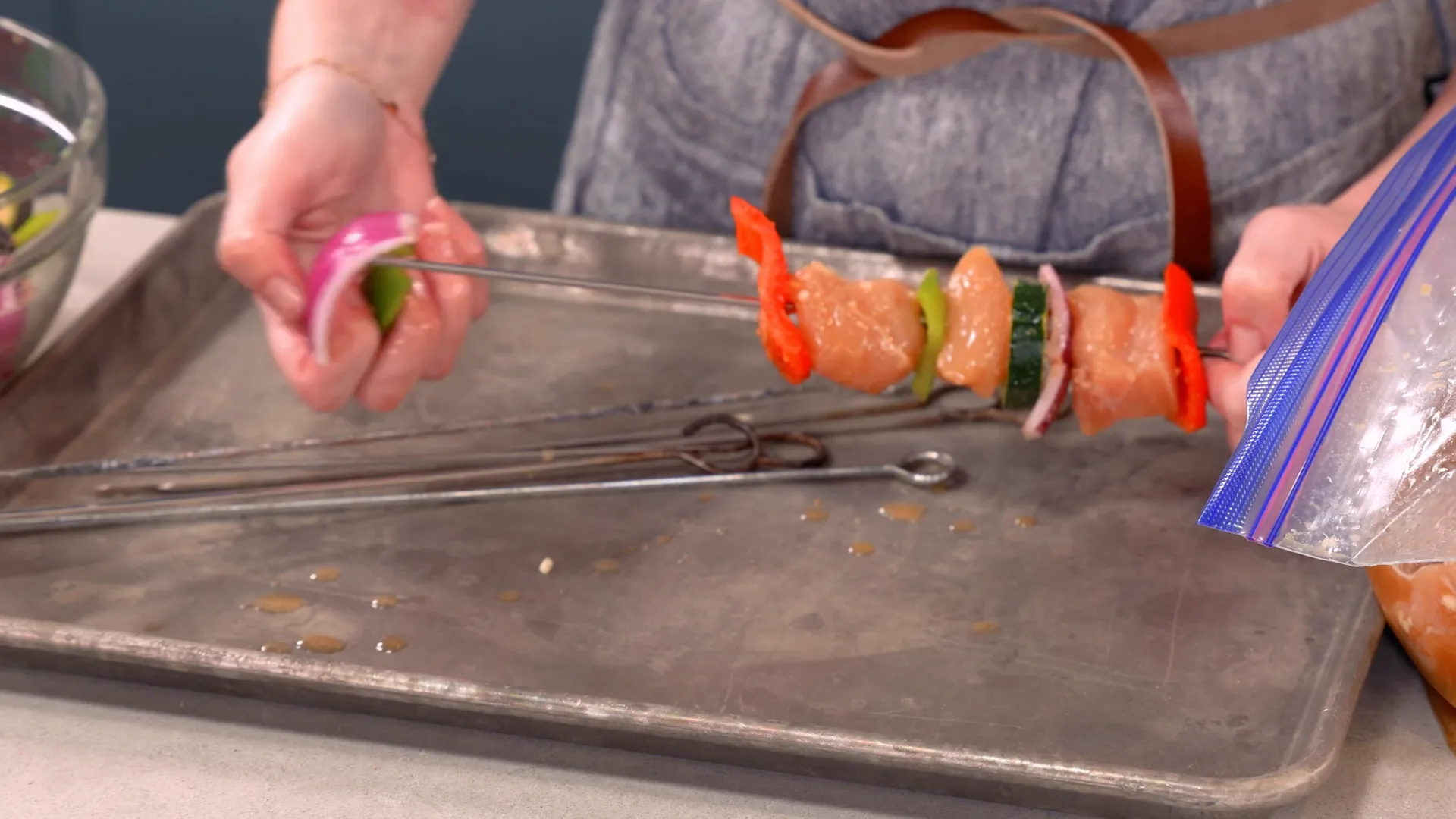 Threading chicken and vegetables onto skewers