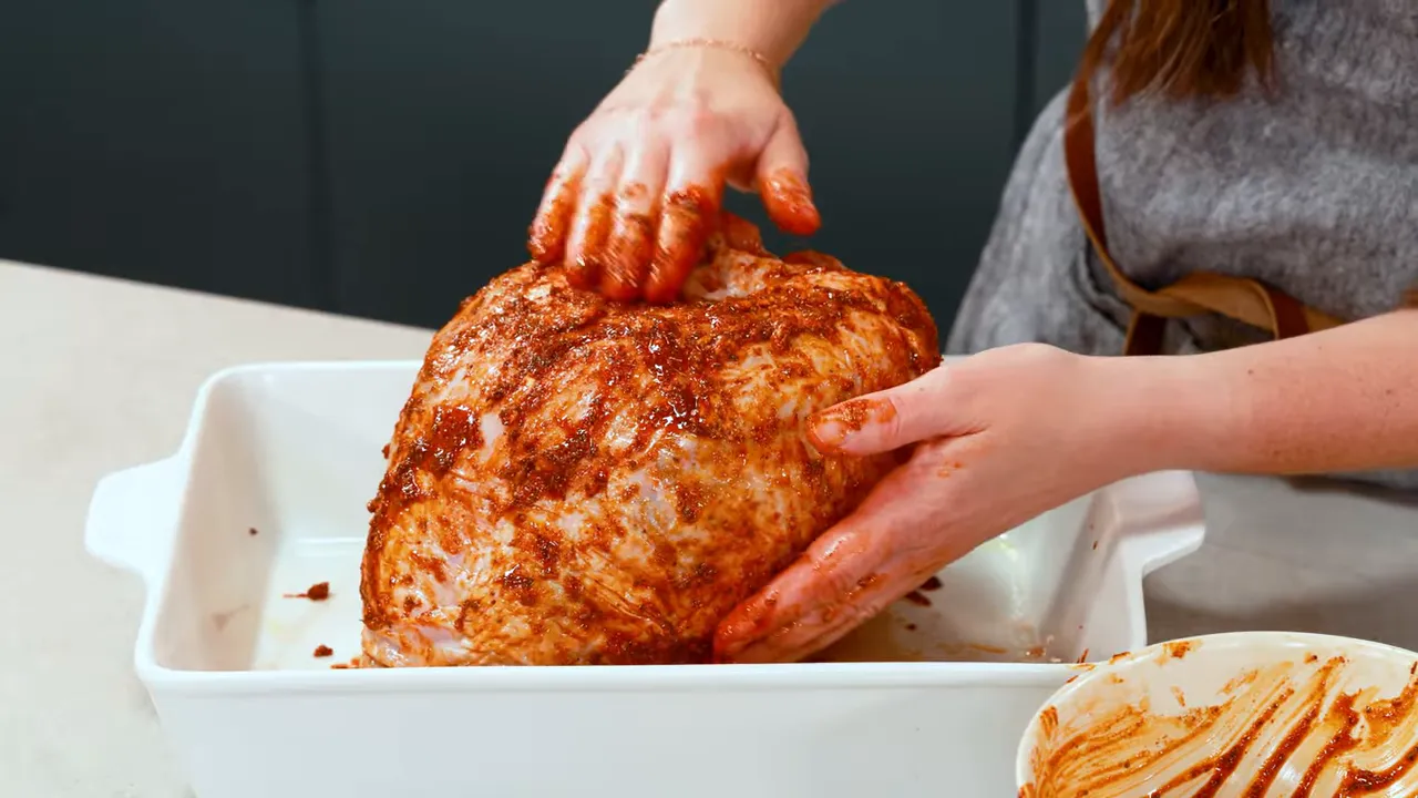 Rubbing the seasoned butter paste over the turkey breast