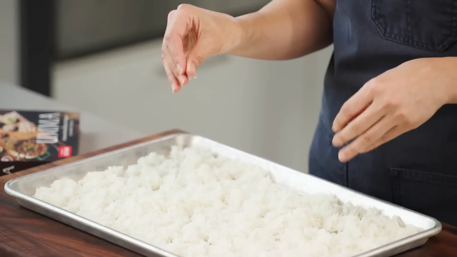 Rimmed baking sheet with freshly cooked rice spread out to cool