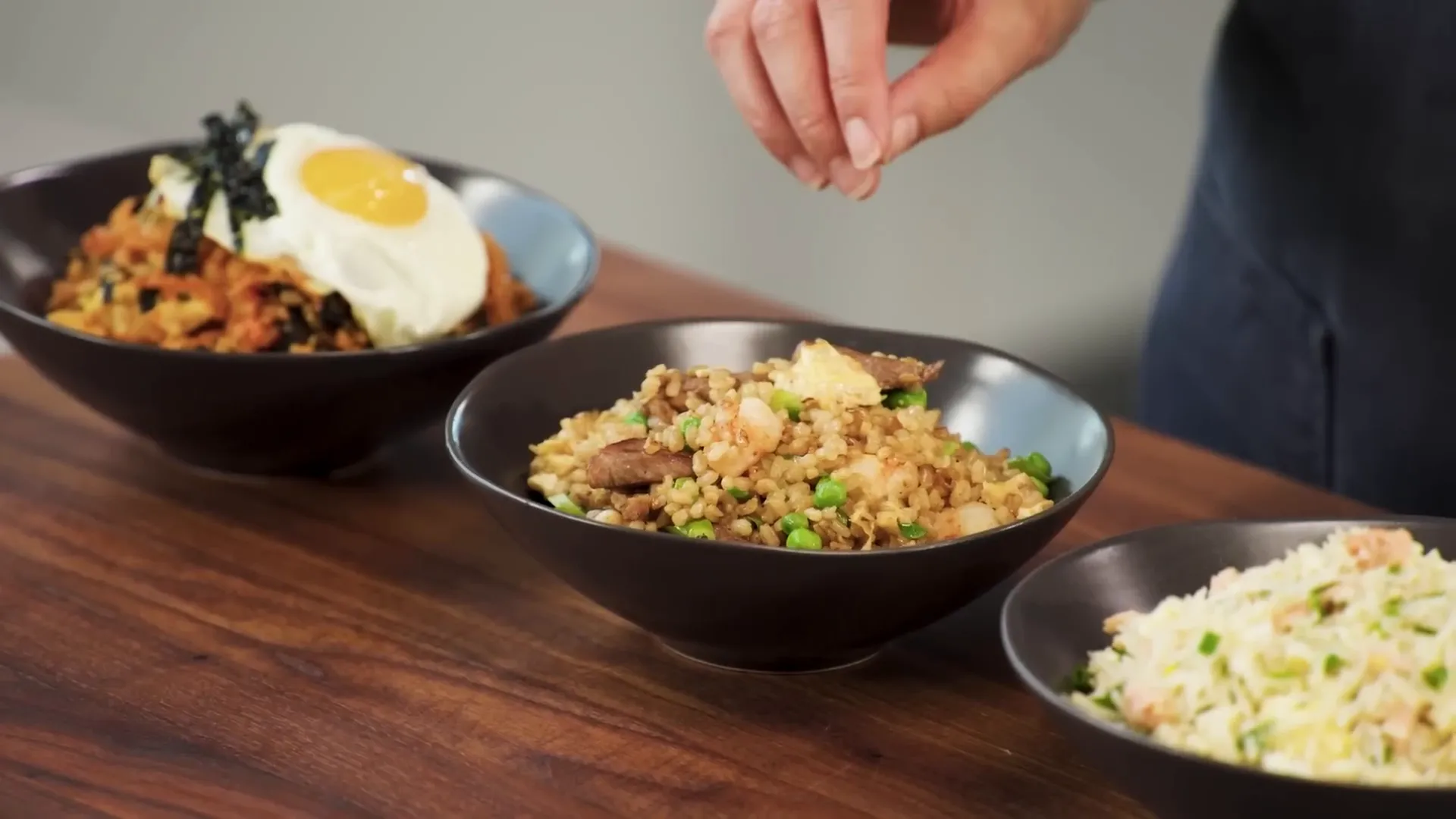 Three styles of fried rice lined up on a counter