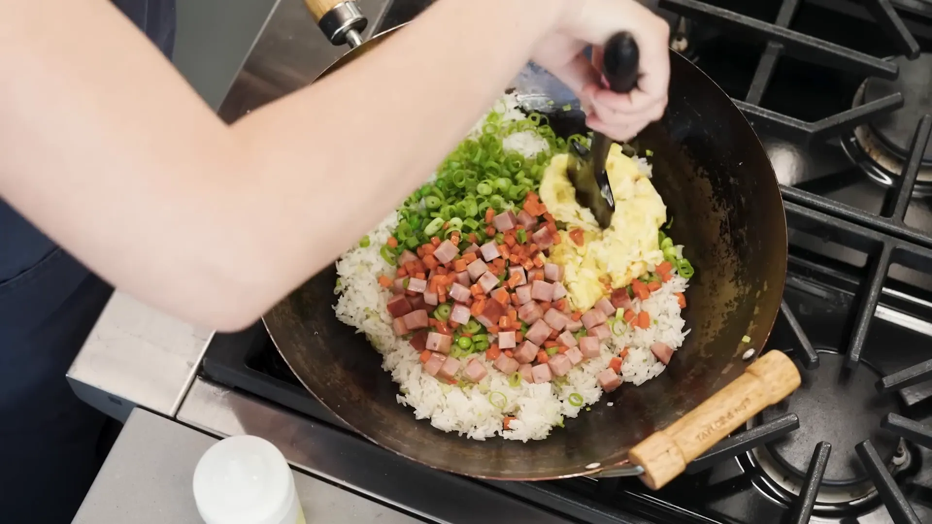 Final toss of fried rice in the wok, steaming and ready to serve