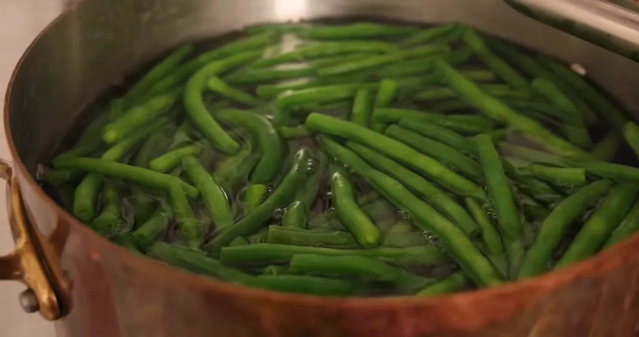 bright green beans boiling in a copper pot during blanching