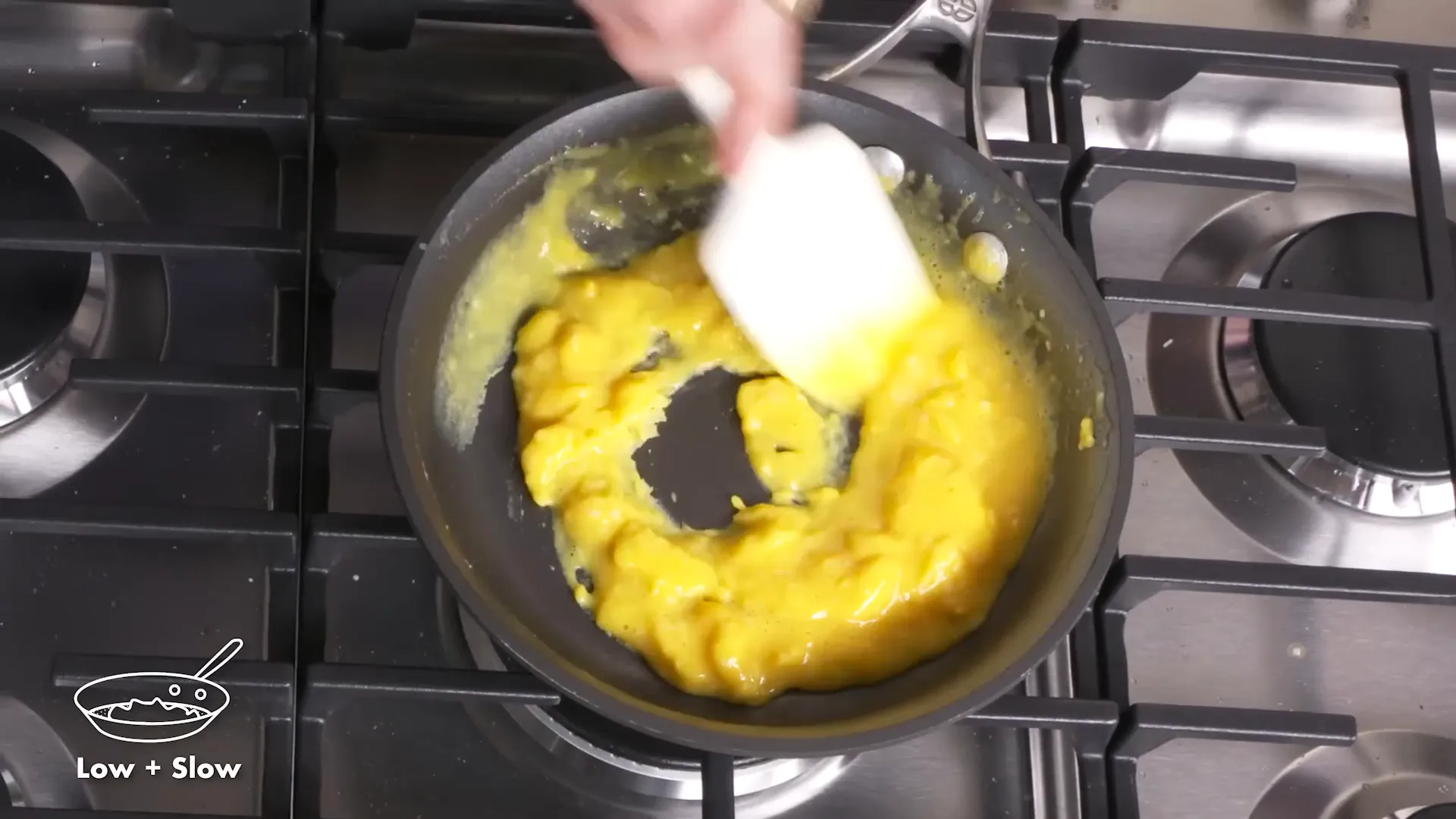 Soft, curdy scrambled eggs being stirred