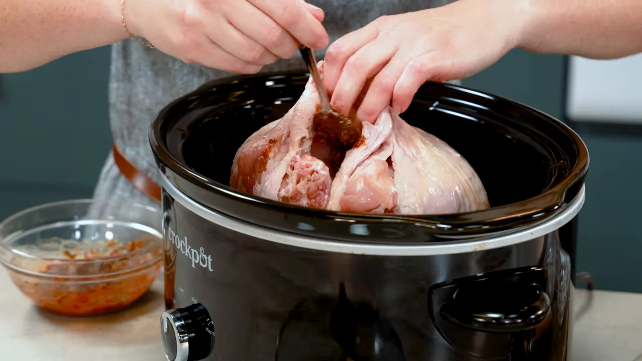 Finger sliding under the turkey skin to add seasoning