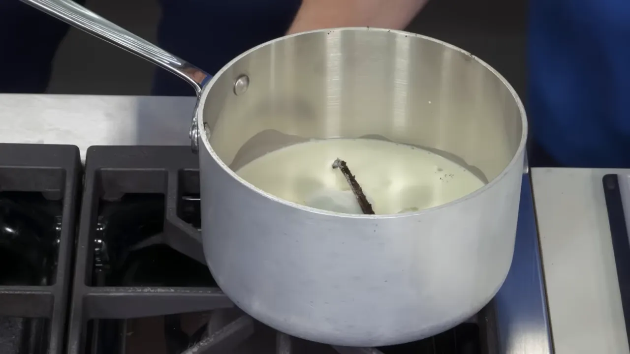 Vanilla bean split and seeds added to cream while whisking