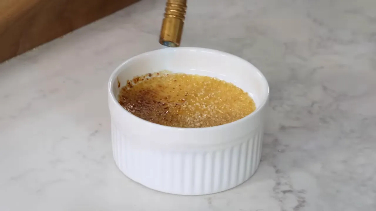 Using a small torch to caramelize the sugar on crème brûlée