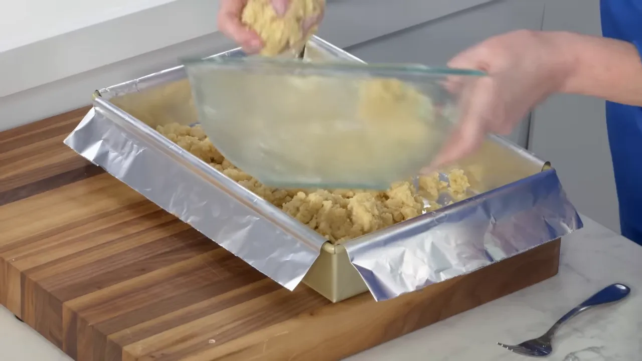 Shortbread crust crumbled into a foil-lined 9 by 13 inch pan