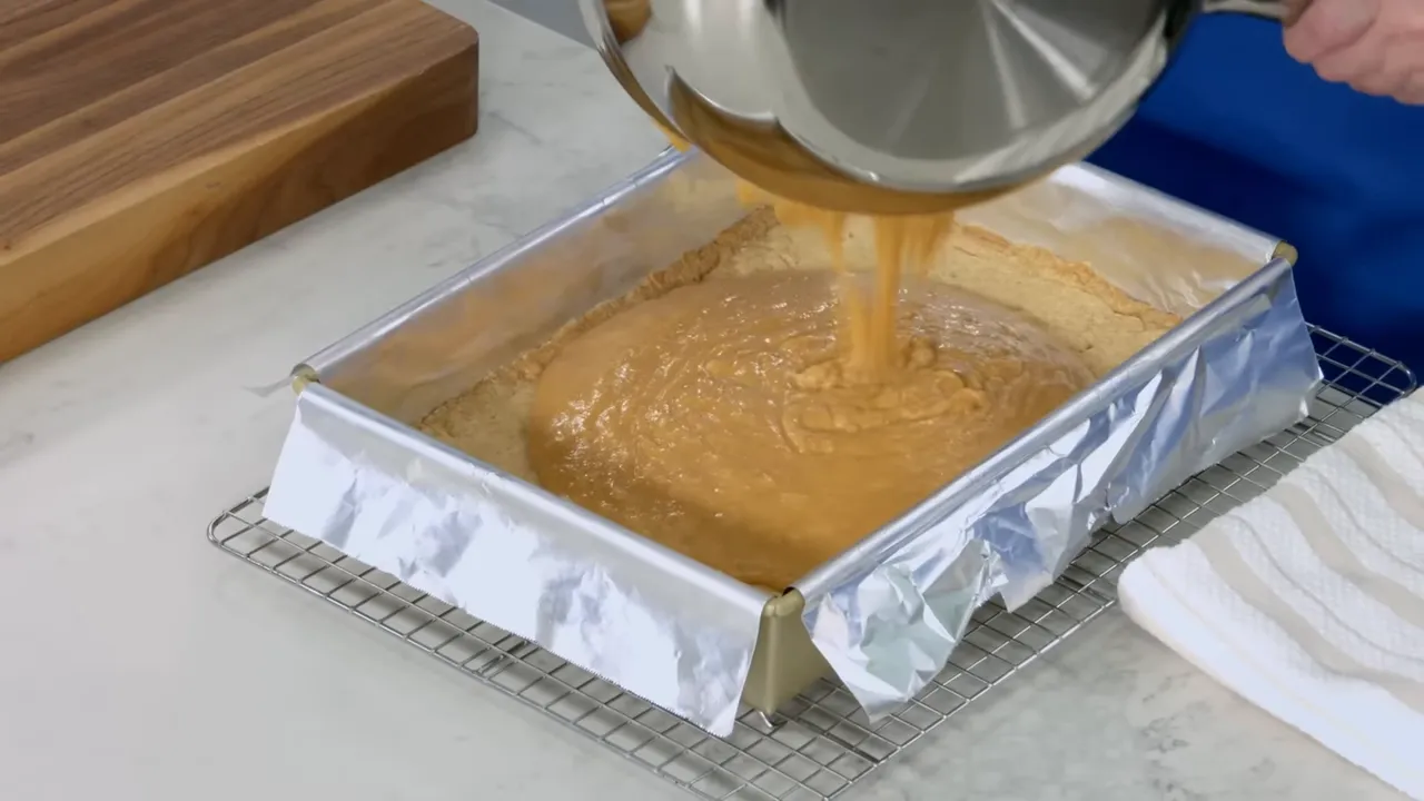 Hot toffee being poured over baked shortbread crust