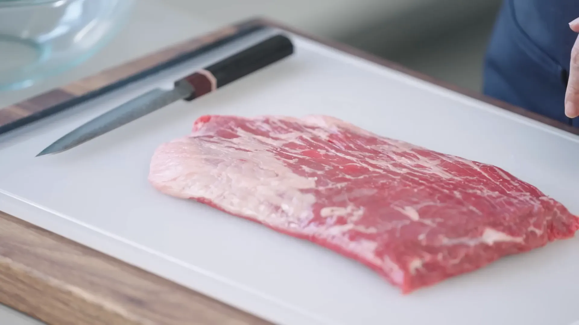 Raw flank steak on cutting board before trimming
