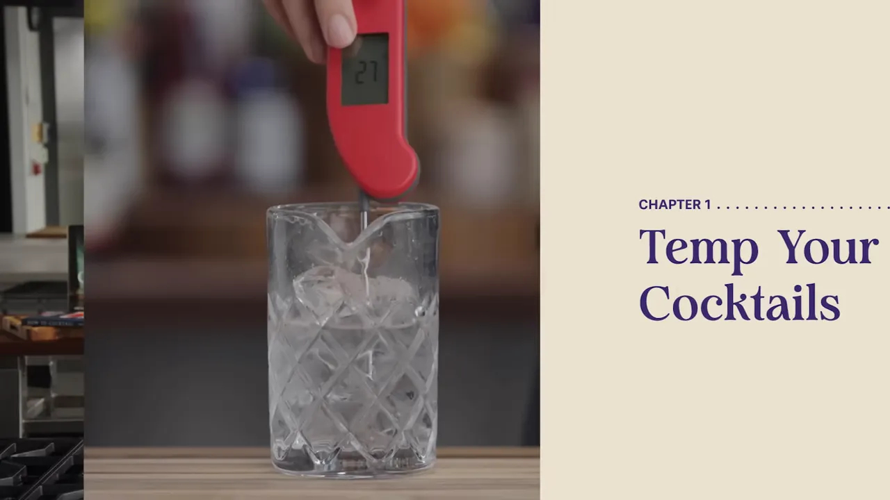 Hand holding a cocktail thermometer above a glass