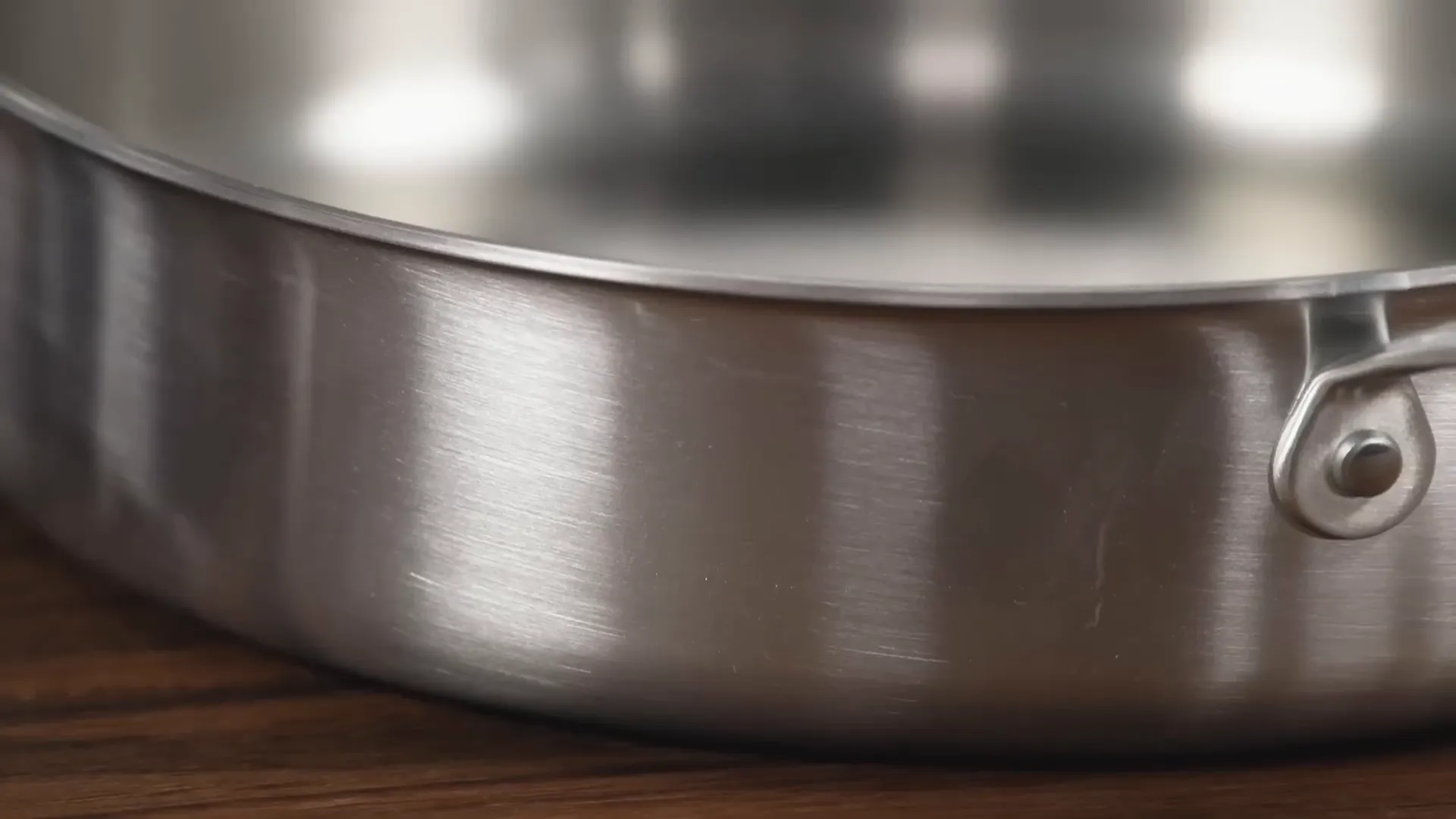 cross-section diagram showing clad construction of sauté pan with aluminum core and stainless steel layers