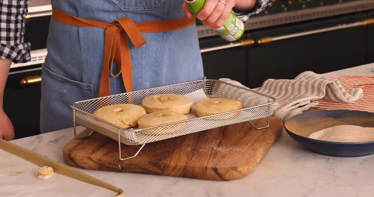 Brushing donuts with melted butter and coating with cinnamon sugar