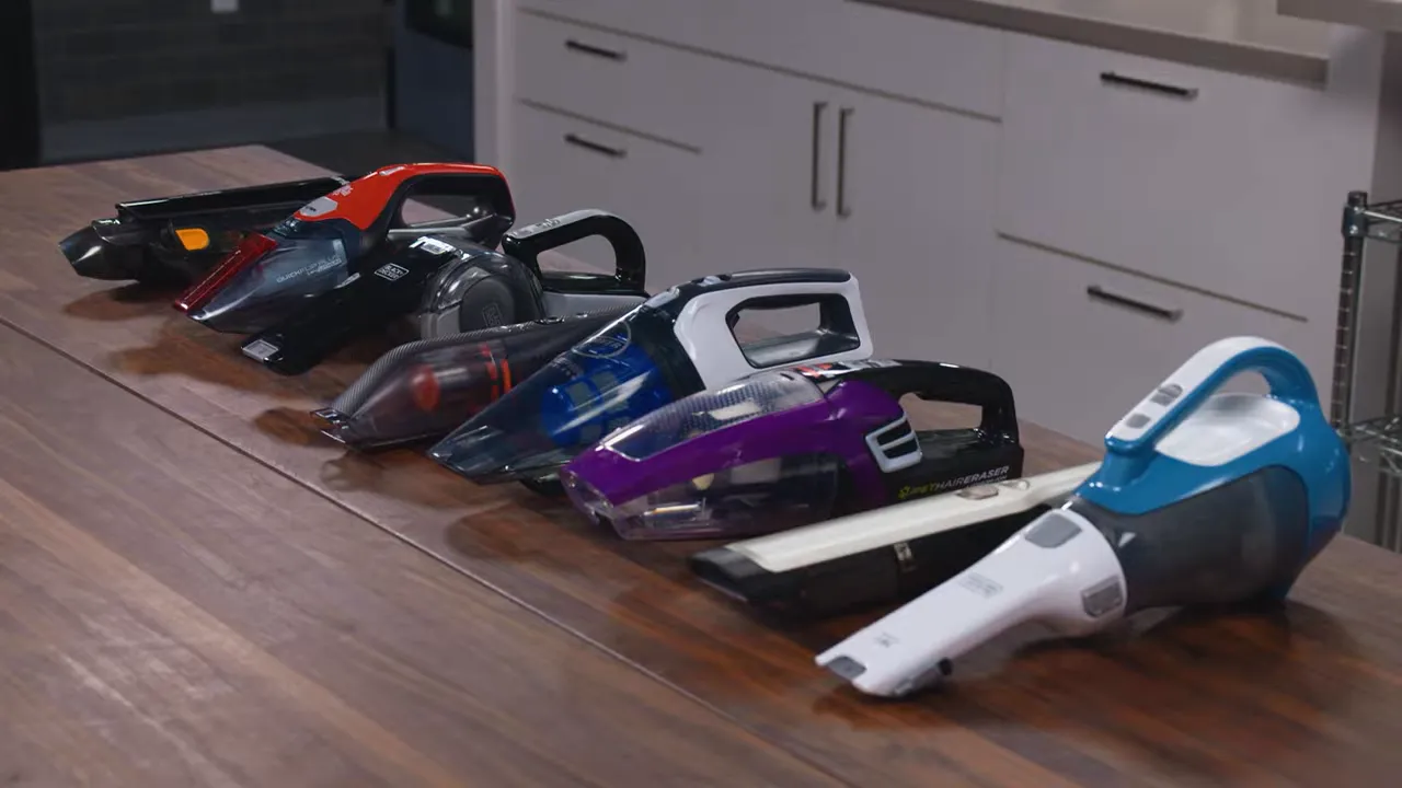 row of handheld vacuums arranged side by side on a wooden kitchen counter