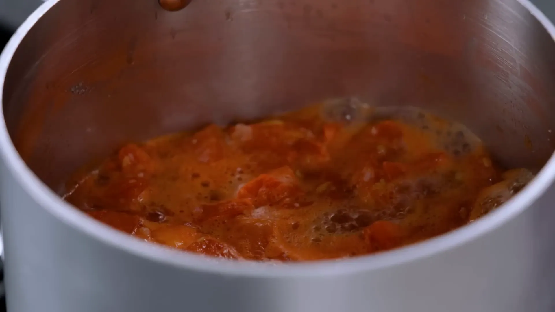 Simmering tomato jam in a saucepan