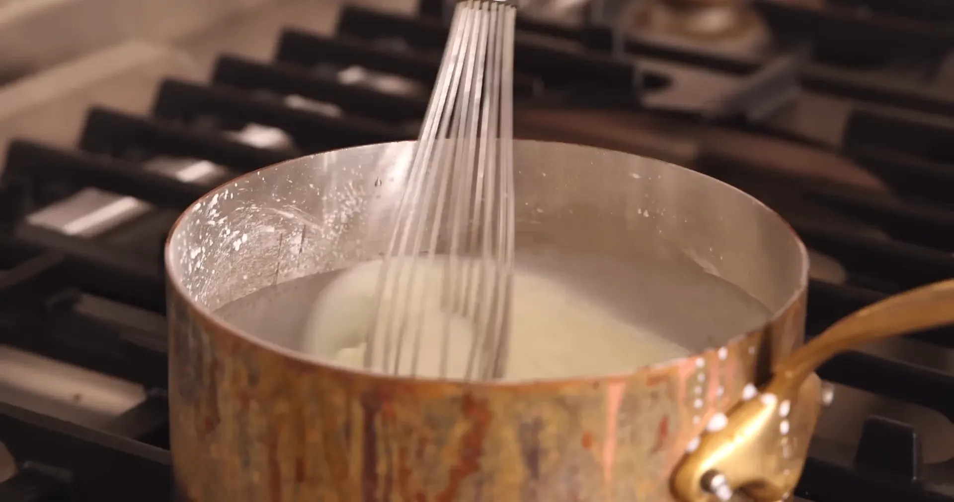 Whisking milk and cornstarch mixture on the stove to thicken