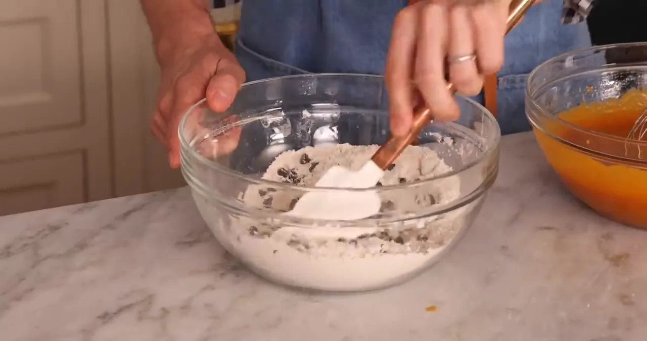 Chocolate chips being added to the dry ingredients