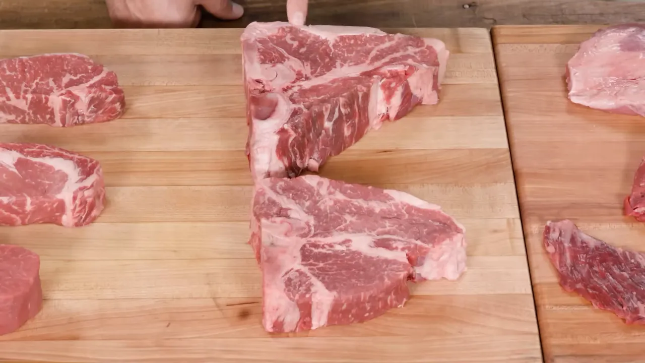two T‑bone porterhouse steaks on a wooden cutting board showing bone and marbling