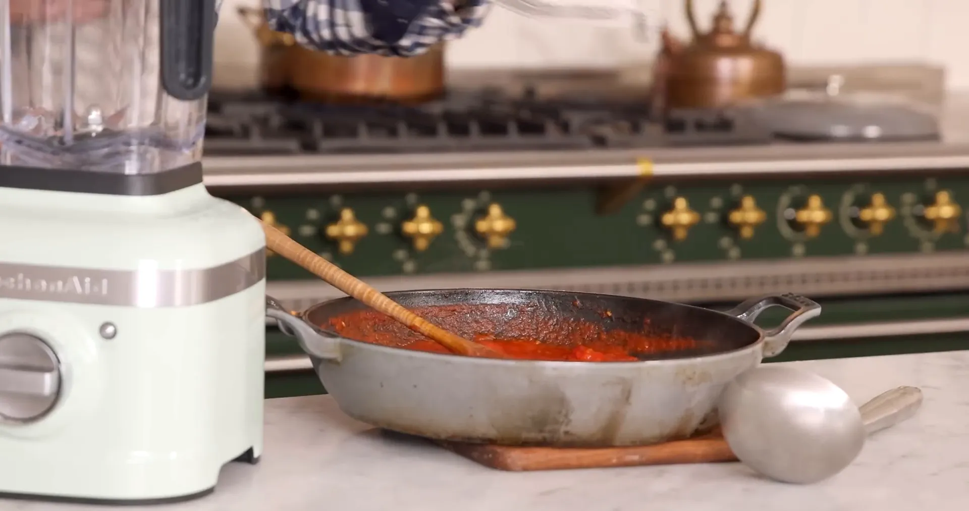 Ladling hot tomato sauce into blender for smooth consistency