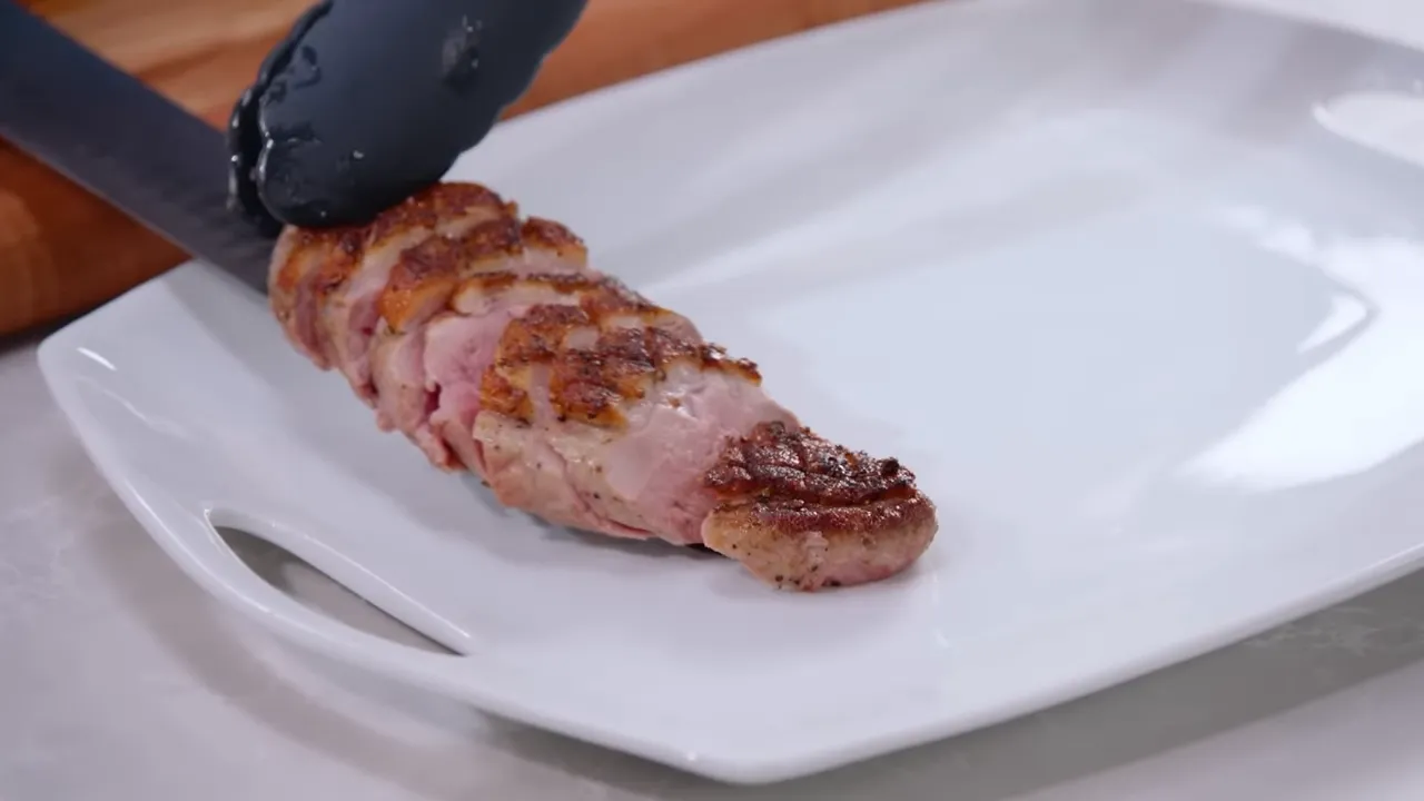 sliced duck breast arranged on white serving plate ready to serve