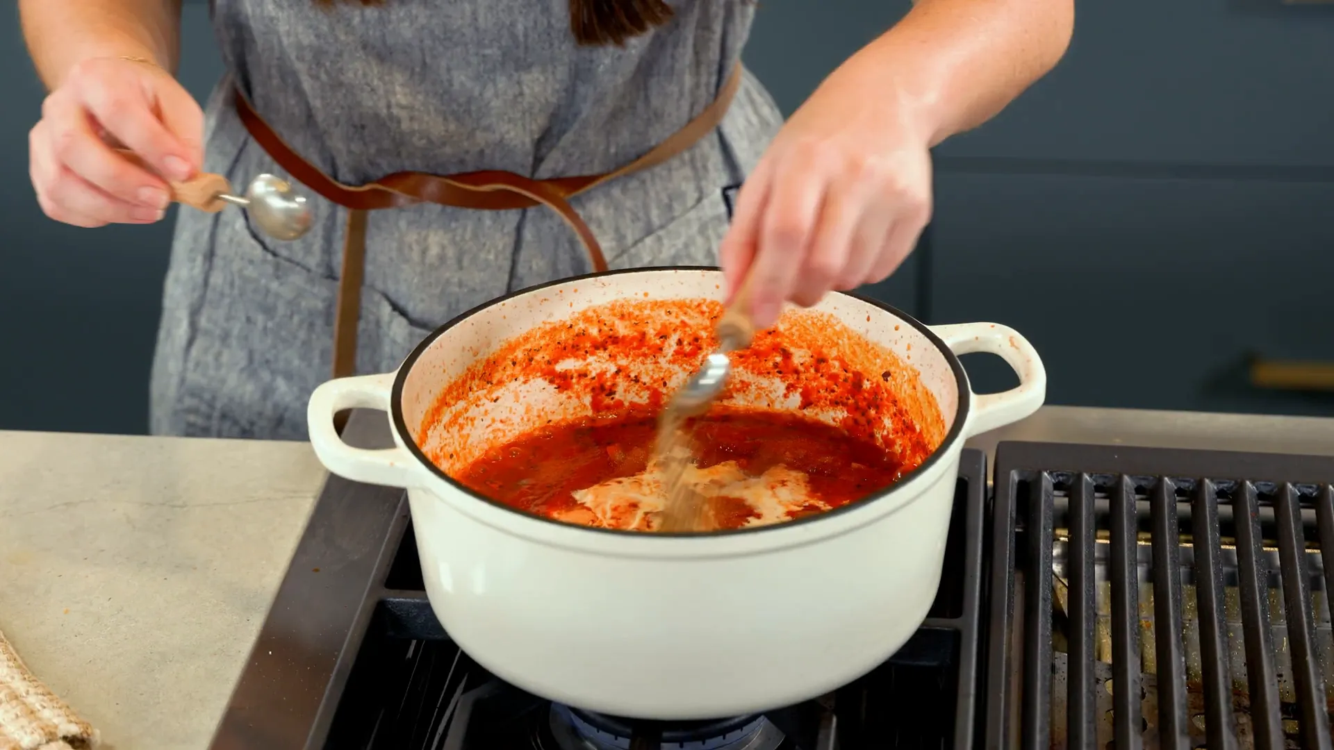 Pouring vodka into the sauce while cooking
