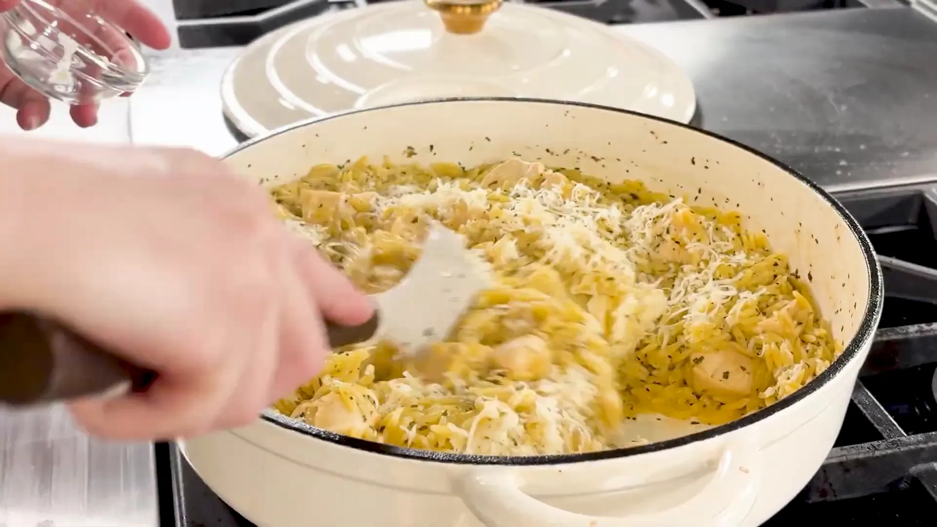 Stirring Parmesan cheese and butter into cooked orzo