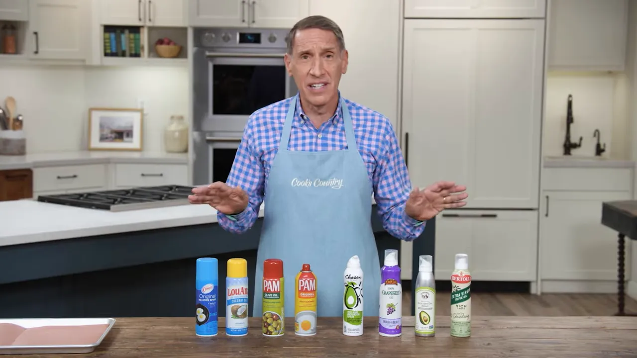 Presenter demonstrating a row of cooking spray cans on a kitchen counter, showing a variety of spray types.