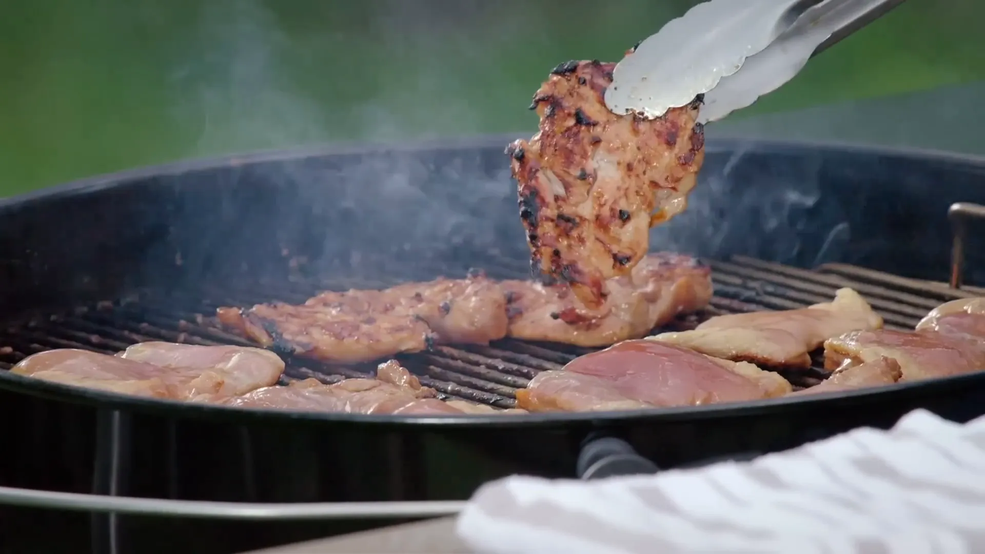 Chicken thighs grilling with perfect char marks
