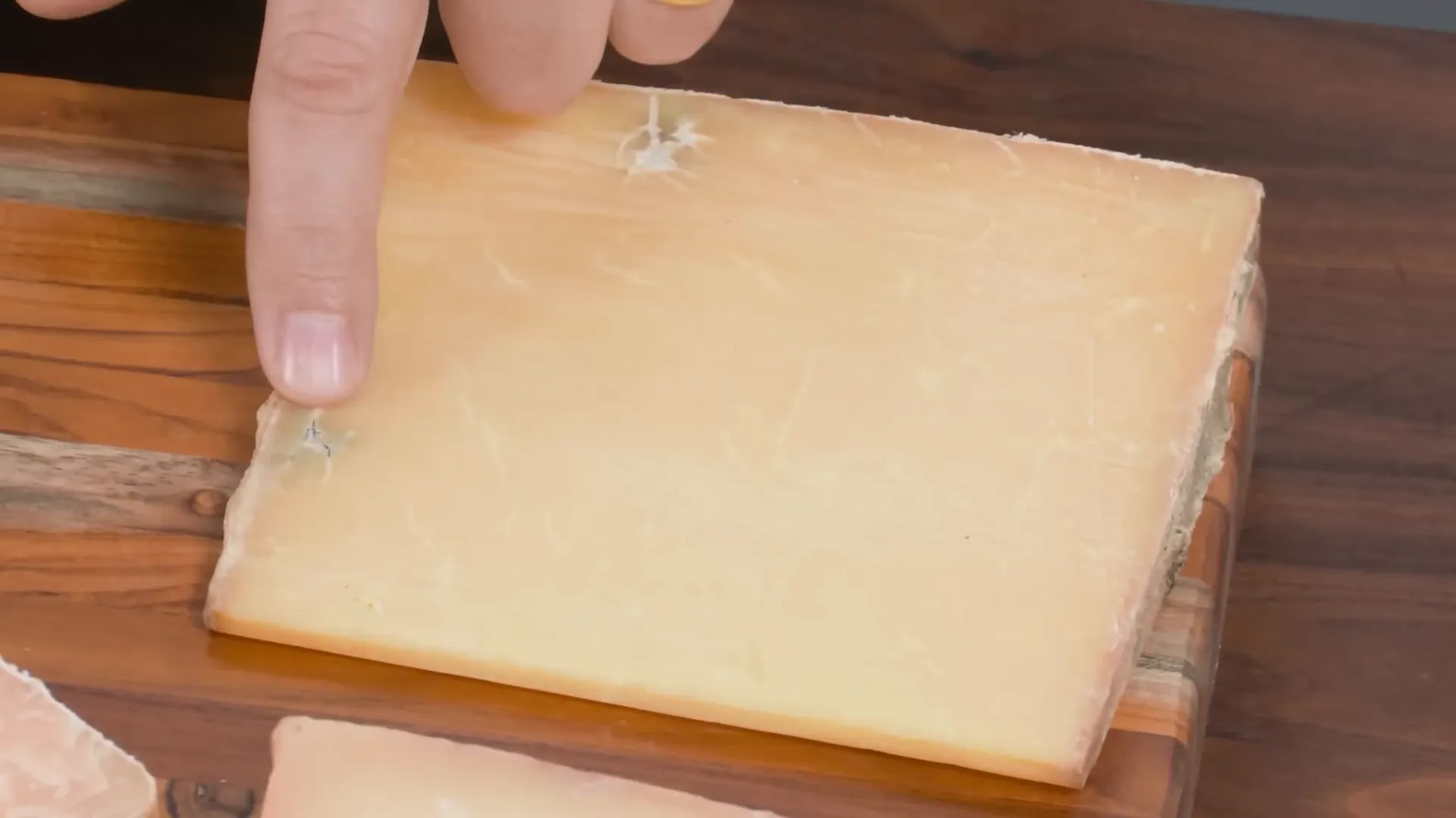 Clothbound cheddar cheese showing fissures and aged rind