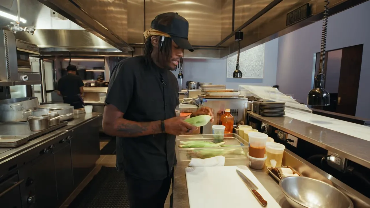 Chef tasting and testing corn egusi stew in production kitchen